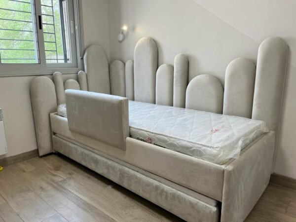 מיטה דגם אייקון עם קיר מרופד לאורך המיטה